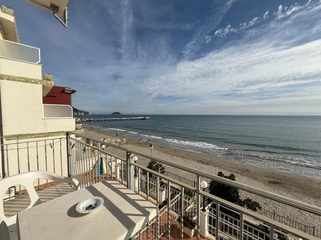 Balcone con tavolo e vista panoramica sulla spiaggia e il mare