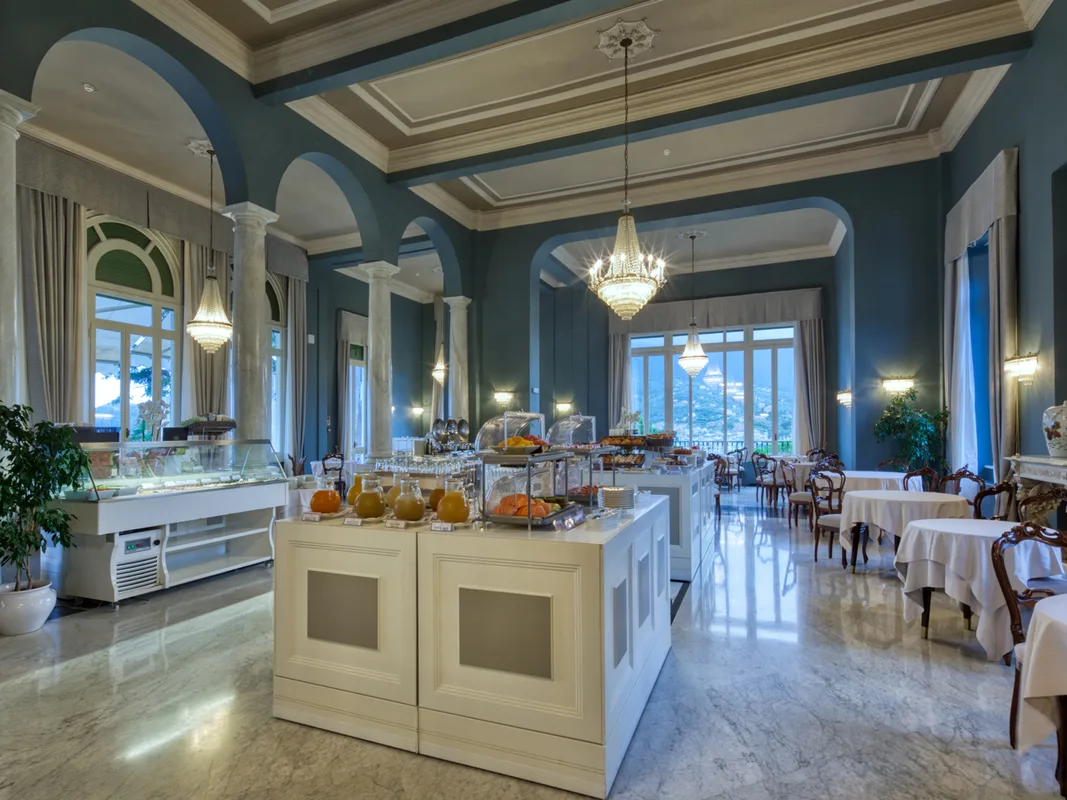 Sala buffet della colazione con isole espositive, lampadario di cristallo e ampie finestre
