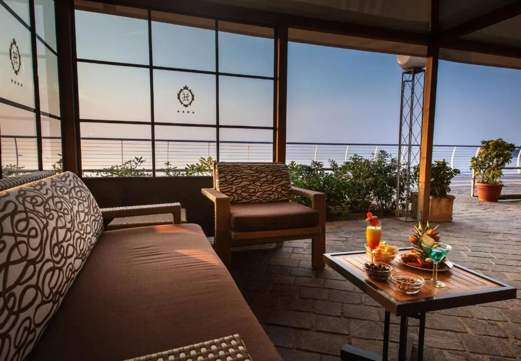 Salottino coperto con divano, poltrona e aperitivo con vista sul mare