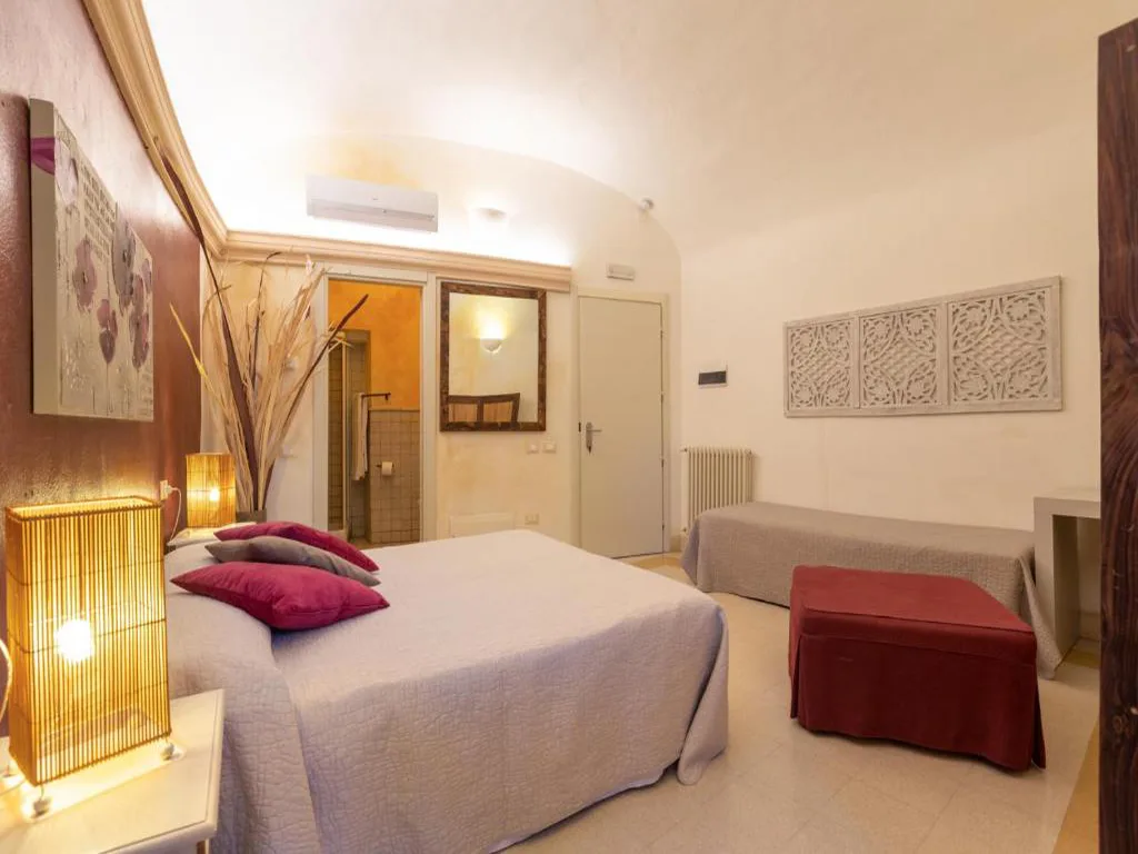 Camera tripla con letto matrimoniale, letto singolo e arredi in stile mediterraneo