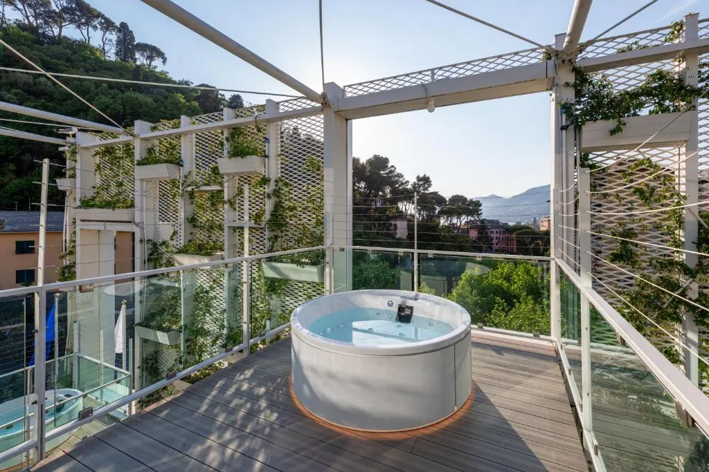 Vasca idromassaggio su terrazza con pergolato bianco e vista sul verde circostante