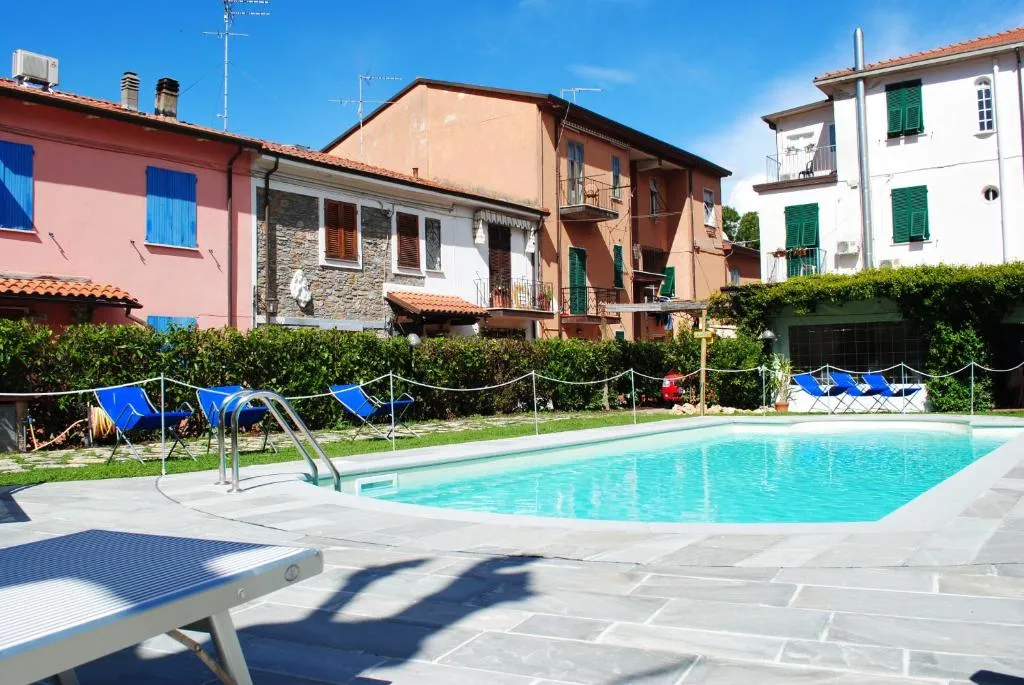Piscina esterna con lettini blu tra le case del borgo