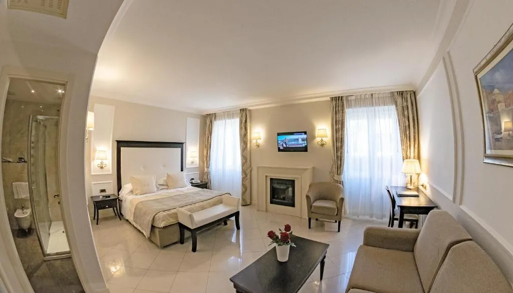 Ampia camera elegante con letto, camino, zona salotto e bagno con doccia