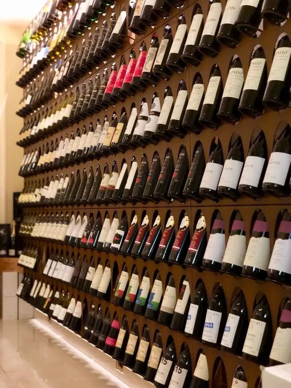 Parete espositiva con ampia selezione di bottiglie di vino