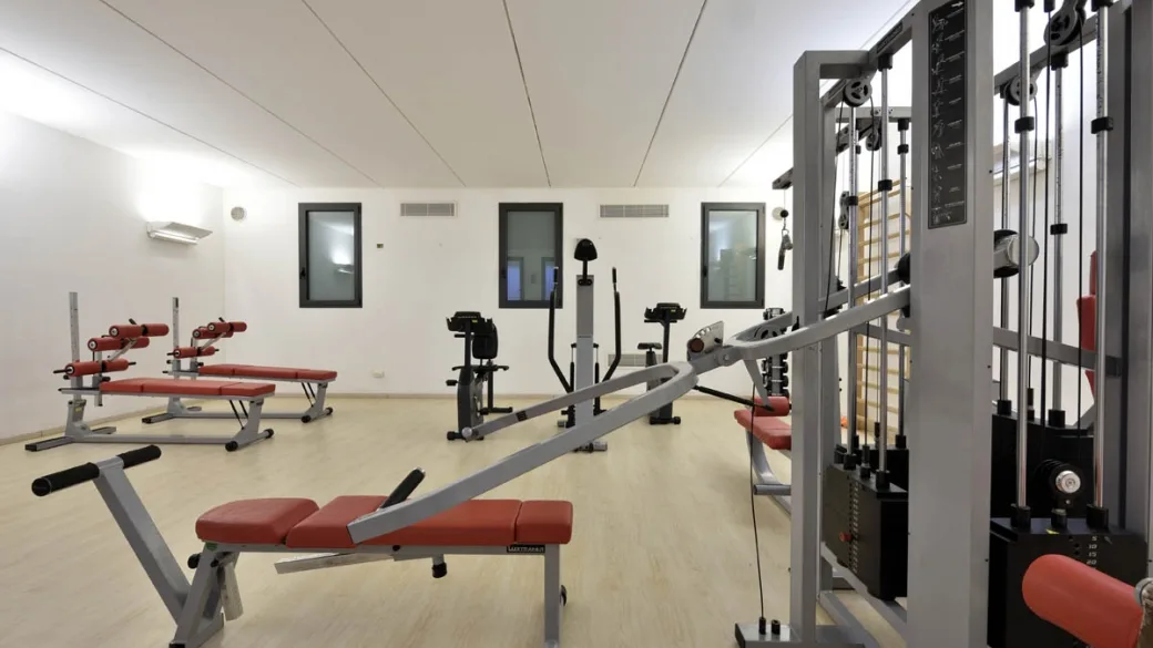 Sala fitness con macchinari e panche per allenamento