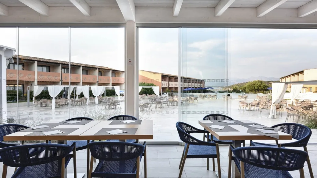 Sala ristorante con tavoli apparecchiati e vista sulla terrazza esterna