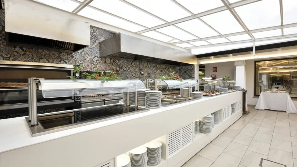Buffet del ristorante con stazione grill e piatti impilati