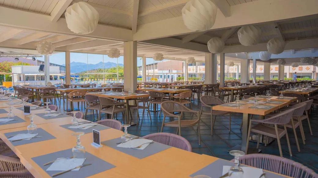 Ampia sala ristorante con tavoli e vista panoramica sulle montagne