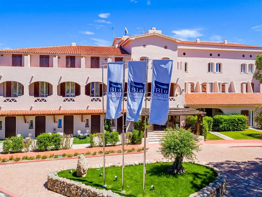 Ingresso dell'hotel Blu Hotels con bandiere e giardino curato