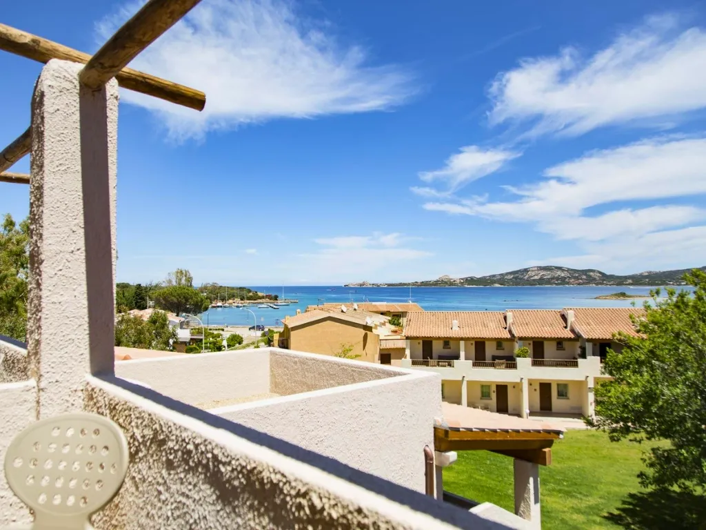 Vista mare dal balcone della camera con porticciolo e costa in lontananza