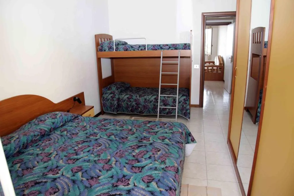 Camera con letto matrimoniale e letto a castello, arredo essenziale