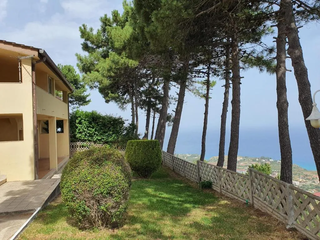 Giardino con pini affacciato sul mare e vista panoramica della costa