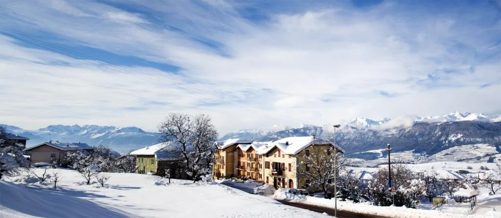 Panorama invernale del paese con l'hotel e le Dolomiti innevate